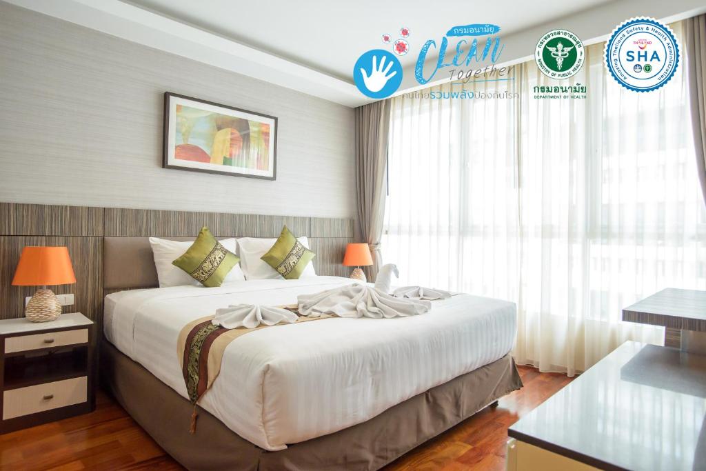 1 dormitorio con 1 cama blanca grande en una habitación en GM Serviced Apartment (SHA Certified), en Bangkok