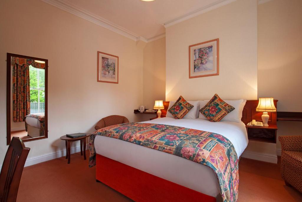 um quarto de hotel com uma cama e uma janela em Arundel House Hotel em Cambridge