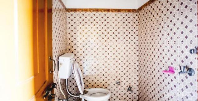 uma casa de banho com um WC e uma parede em azulejo em Shri Gobind Highway Motel em Lansdowne