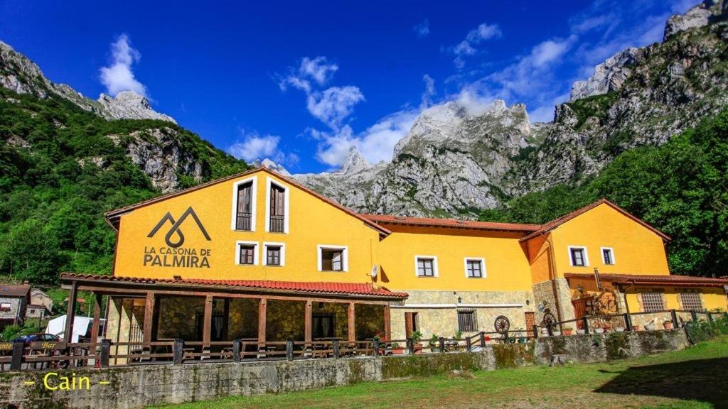 a yellow building with a mountain in the background at LA CASONA DE PALMIRA in Caín