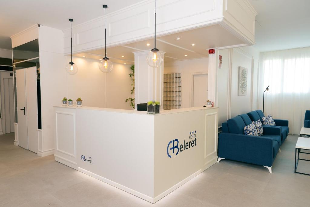 a lobby with a blue couch and a counter at Hotel Beleret in Valencia