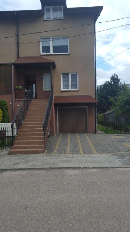 a house with stairs and a garage in front of it at Wiola in Żelistrzewo