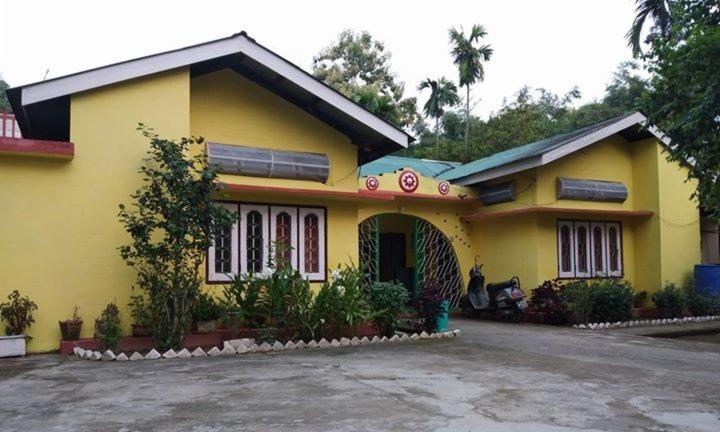 ein gelbes Haus mit einer Einfahrt davor in der Unterkunft TG Resort in Nāmdāng