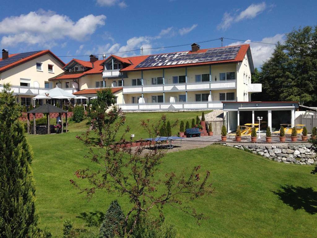 a large white building with a yard in front of it at Naturhotel Am Sonnenhang in Oy-Mittelberg