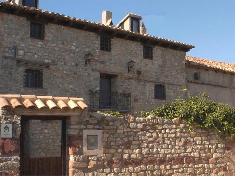 a stone building with a door and a stone wall at Casa La Abuela de Vicente 