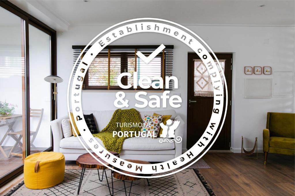 a living room with a sign that reads clean and safe at Eco Villa do Adro in Porto de Mós