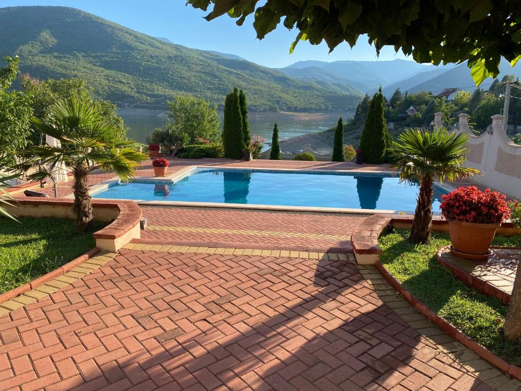 a brick pathway leading to a swimming pool with a view of a mountain at Villa Princess Tikvesh Lake in Kavadarci
