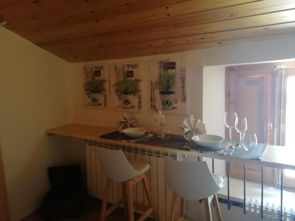 a kitchen with a bar with white stools at Ca La Bruna 