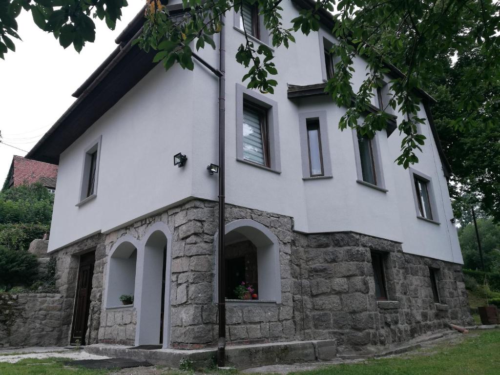 a white house with a stone facade at Willa Sielsko Anielsko in Szklarska Poręba