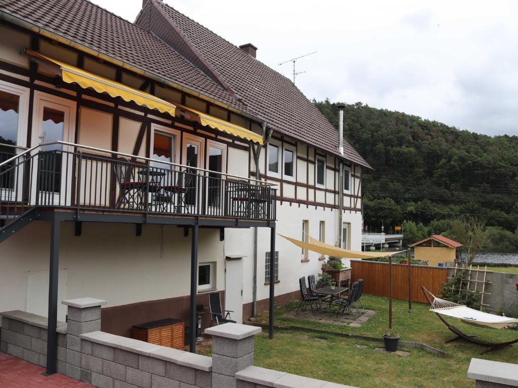 a house with a hammock on the side of it at Ferienwohnungen Eder_Ufer in Hemfurth-Edersee