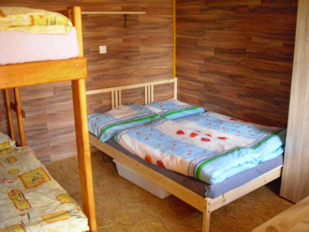 a bedroom with two bunk beds and a wooden wall at Chatová osada jezerní údolí in Stráž pod Ralskem