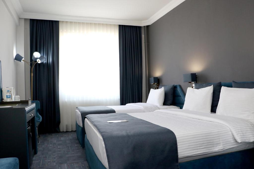 サムスンにあるMy House Hotelのベッド2台と窓が備わるホテルルームです。