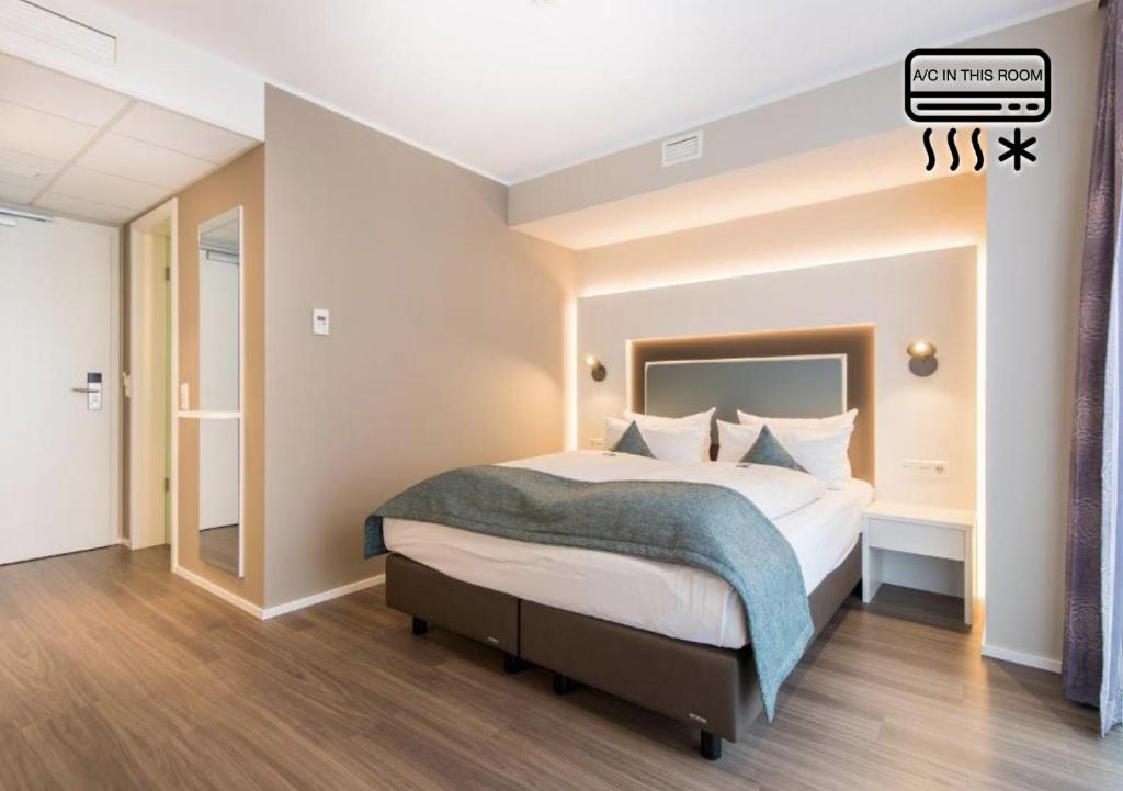 Postel nebo postele na pokoji v ubytování Stadthotel Freiburg Kolping Hotels & Resorts