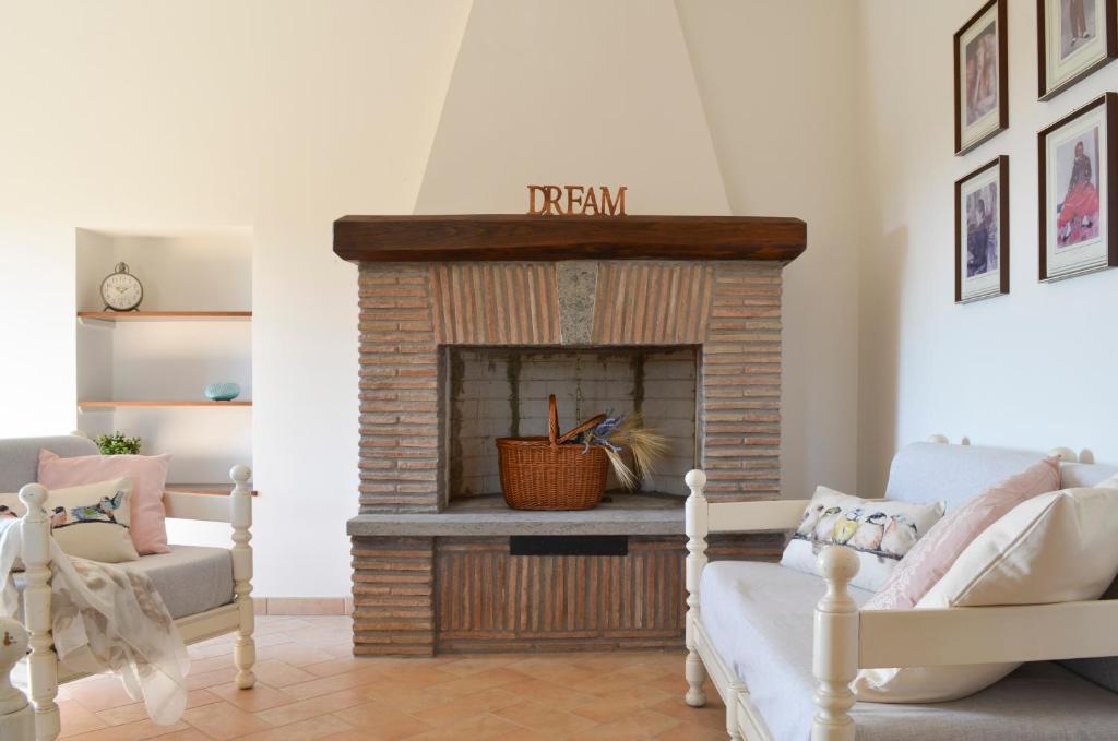 a living room with a fireplace and two chairs at Caratteristico appartamento nel cuore della Tuscia in Vetralla