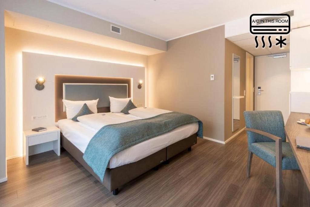 um quarto de hotel com uma cama, uma mesa e uma secretária em Stadthotel Freiburg Kolping Hotels & Resorts em Friburgo em Brisgóvia