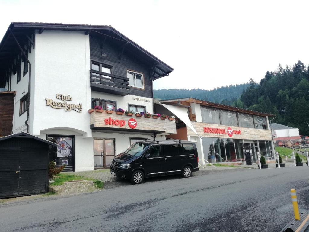 una furgoneta negra estacionada frente a un edificio en Club Rossignol en Poiana Brasov