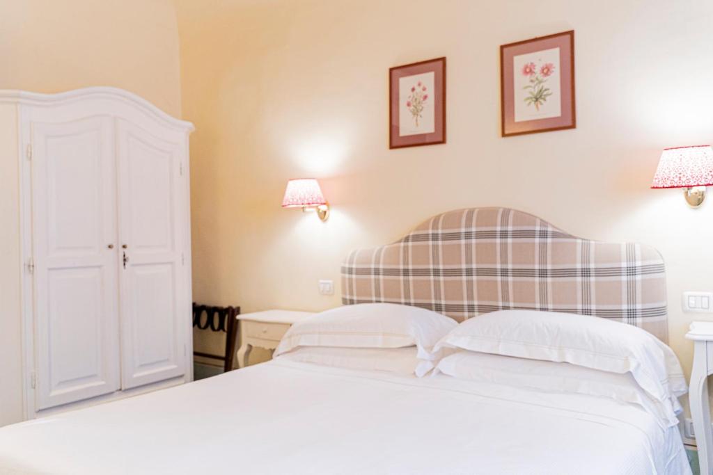 1 dormitorio con 1 cama blanca y 2 lámparas en Casa Uffizi XIII Century Tower House Boutique Hotel en Florencia