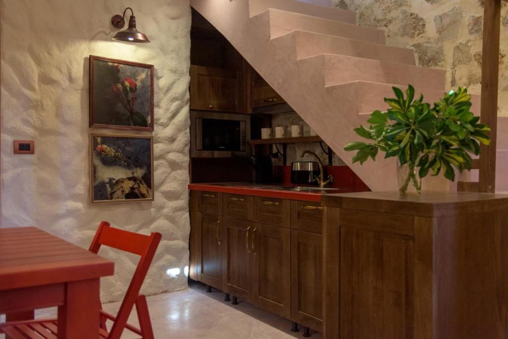 a kitchen with a staircase and a counter with a plant at Roots Dhermi in Dhërmi