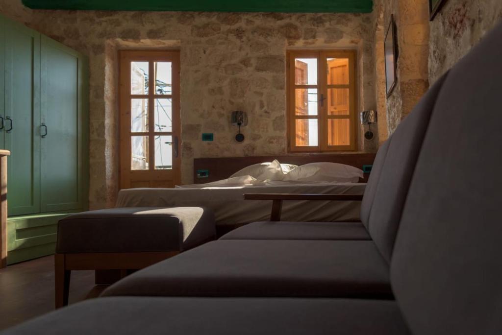 a room with three beds and two windows at Roots Dhermi in Dhërmi