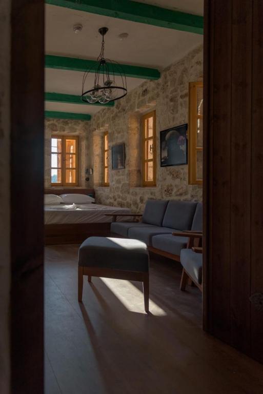 a living room with a couch and a table at Roots Dhermi in Dhërmi