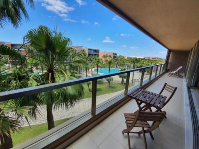 a balcony with a bench and a view of a pool at Ambassador Salgados Beach Suites in Albufeira
