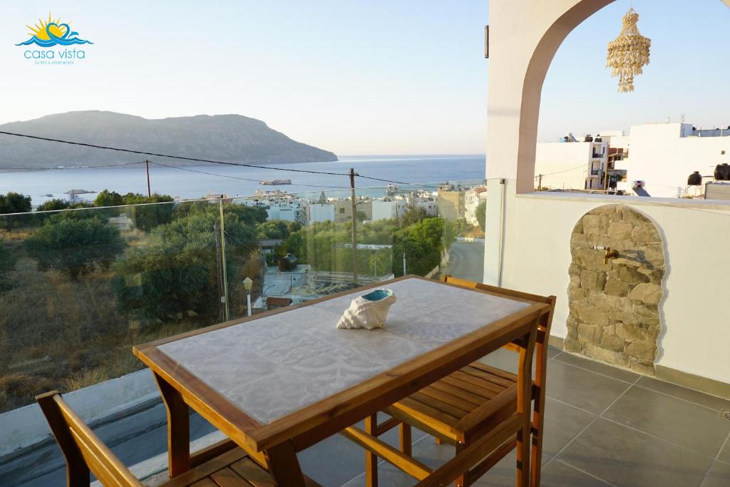 a table on a balcony with a view of the ocean at Casa Vista Summer in Karpathos Town