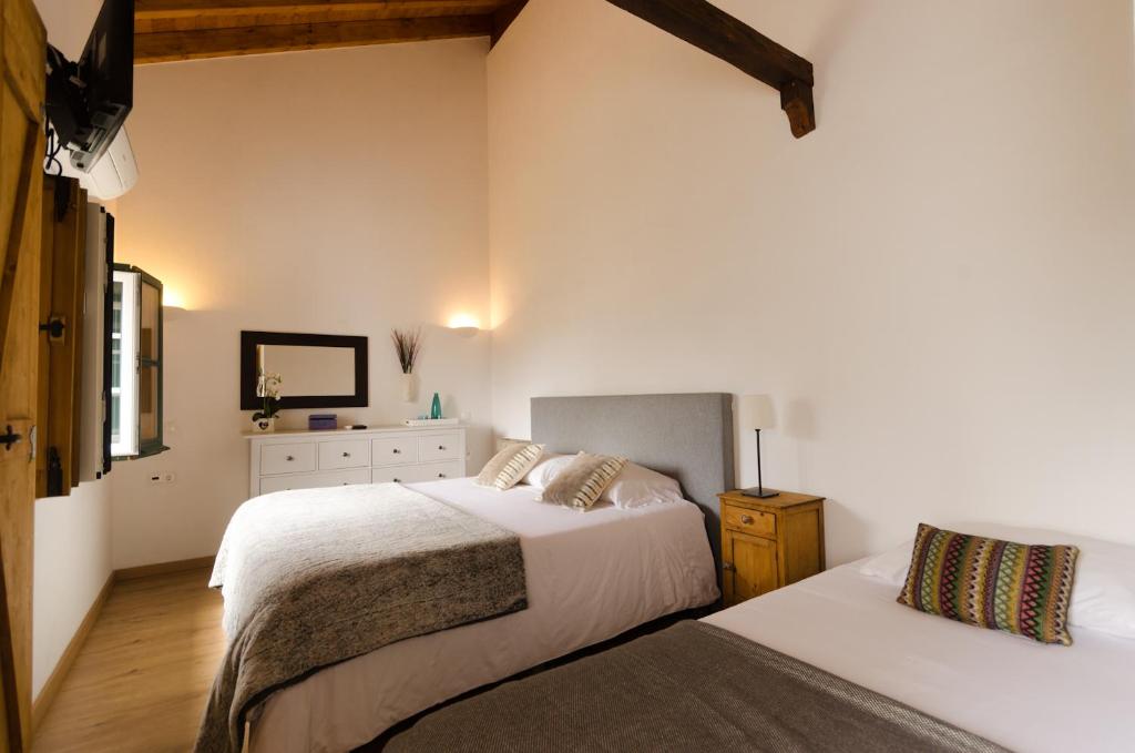 a bedroom with two beds and a dresser at Casa da Torre in Minas de São Domingos