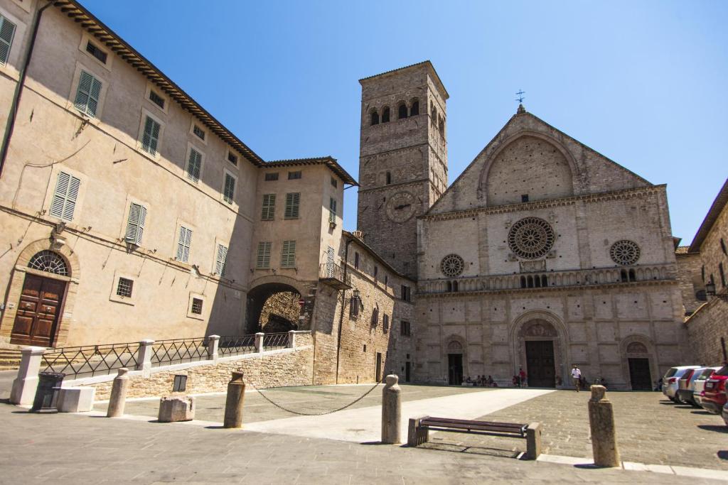 ein großes Gebäude mit einem Turm und einer Kirche in der Unterkunft Casetta del Mastro in Assisi