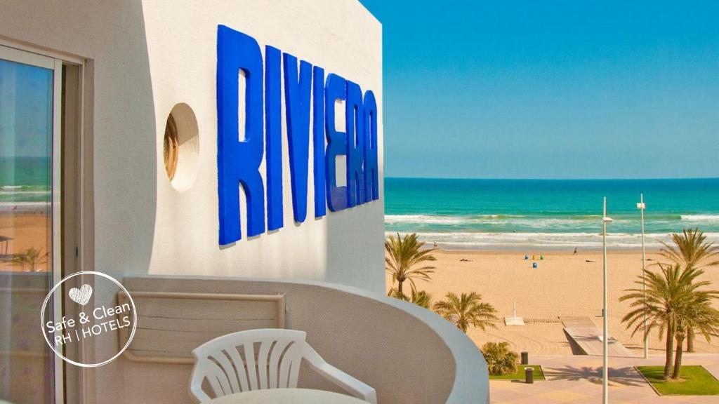 a white and blue beach chair sitting on top of a beach at Hotel RH Riviera - Adults Only in Gandía
