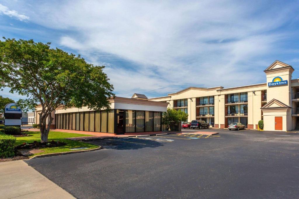 a large building with a parking lot in front of it at Days Inn by Wyndham Hampton Near Coliseum Convention Center in Hampton