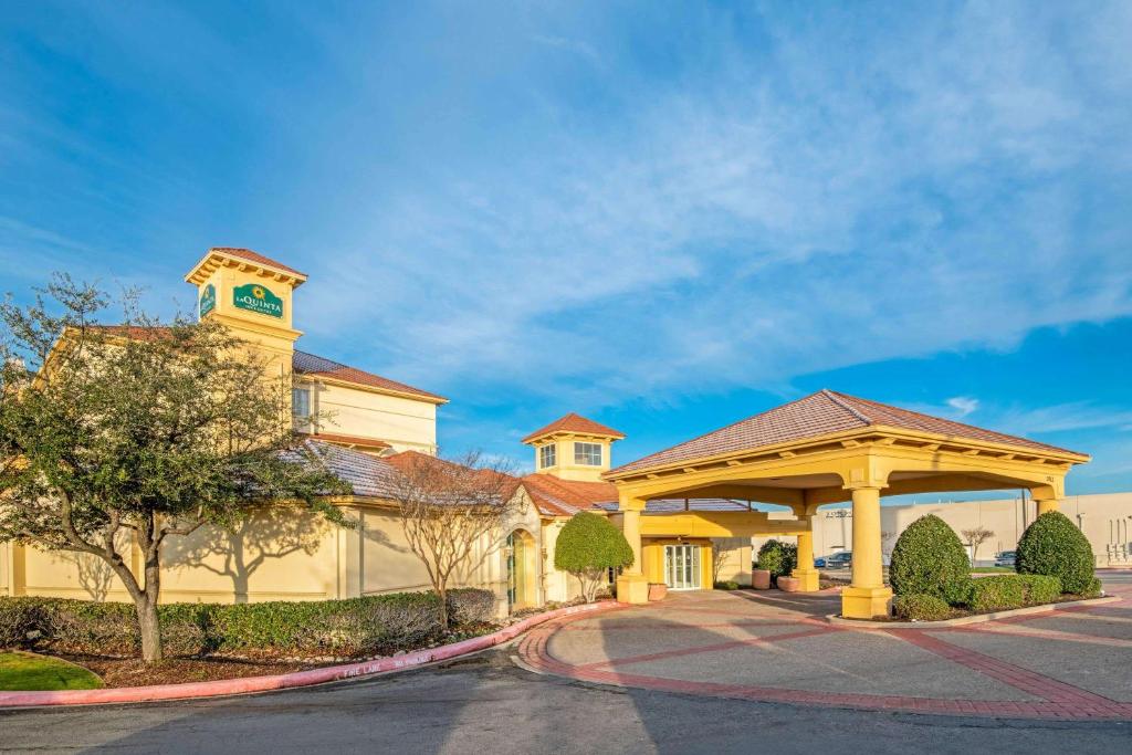 a large yellow building with a clock tower at La Quinta by Wyndham Sherman in Sherman