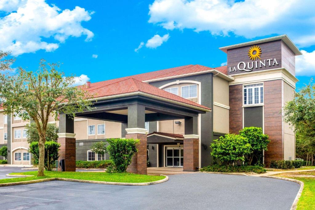 a front view of a hotel with a building at La Quinta by Wyndham Sebring in Sebring