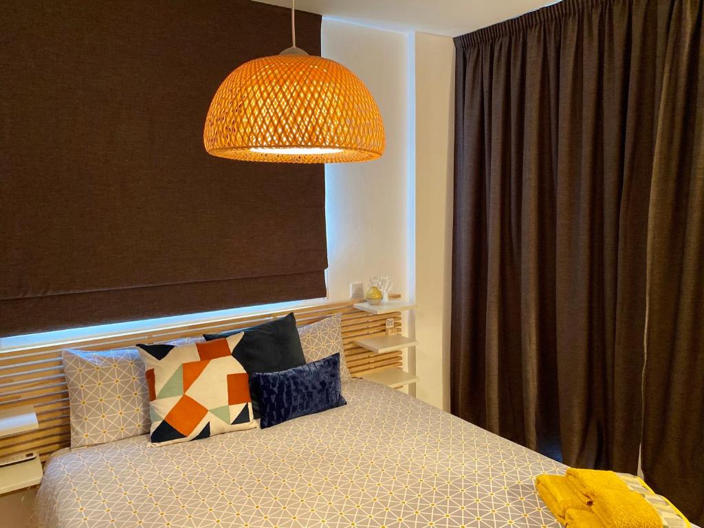 um quarto com uma cama com um candeeiro por cima em Fat Cow Apartment 102 em Livadhia