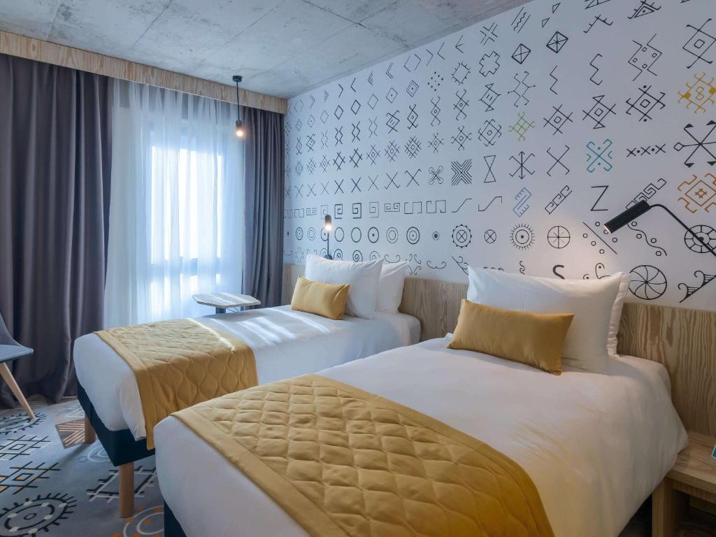 Un pat sau paturi într-o cameră la ibis Styles Bucharest City Center
