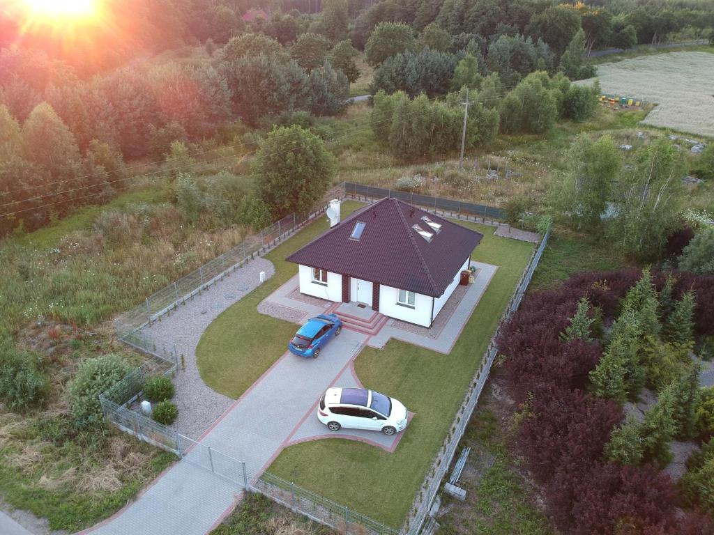 a white car parked in front of a house at Domek pod Lasem in Ustka