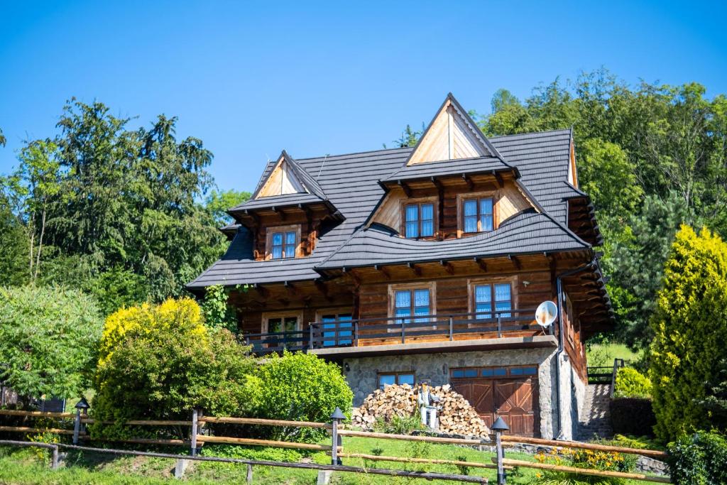 a large wooden house with a gambrel roof at Glisne 69 in Mszana Dolna