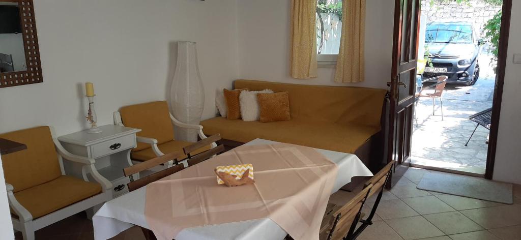 une chambre d&#39;hôpital avec une table, un canapé et une fenêtre dans l&#39;établissement Apartment Nika on the beach Mlini, à Mlini