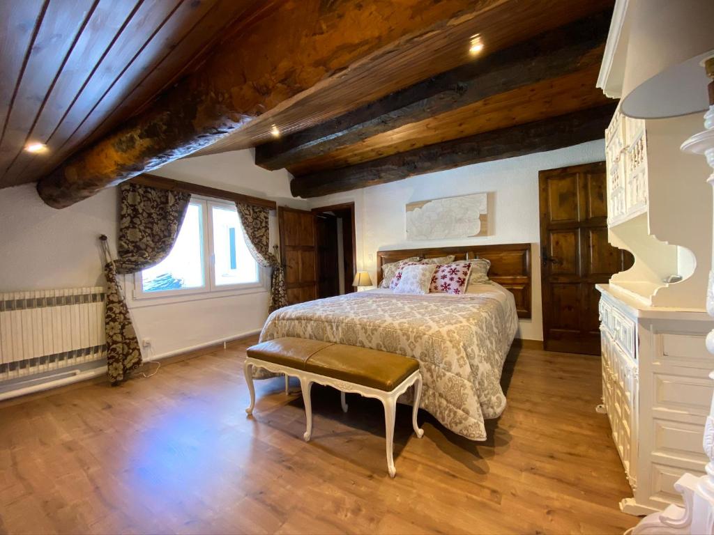 1 dormitorio con 1 cama en una habitación con techos de madera en Apartamento Dúplex Llivia, en Llivia