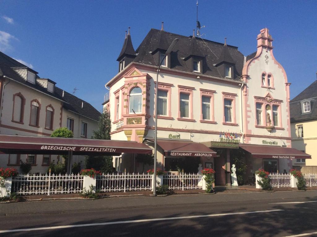 a large building with a white fence in front of it at hotel Deutsches Haus in Wittlich