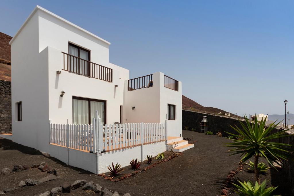 una casa bianca con una recinzione di fronte di Lanzarote Natura Houses a Soo