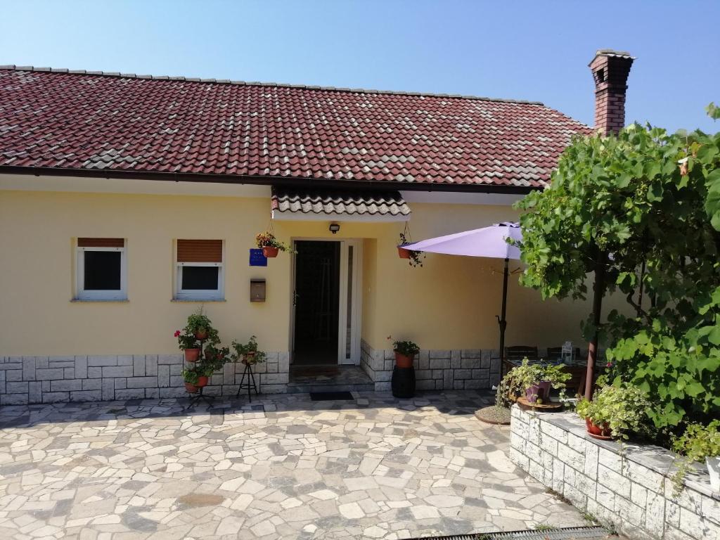 a house with a patio and an umbrella at Studio apartment Vigo - Rijeka in Rijeka