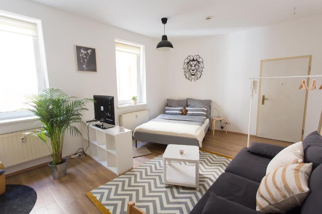 een woonkamer met een bank en een bed bij FULL HOUSE Studios - Lion Apartment - WiFi inkl in Halle an der Saale