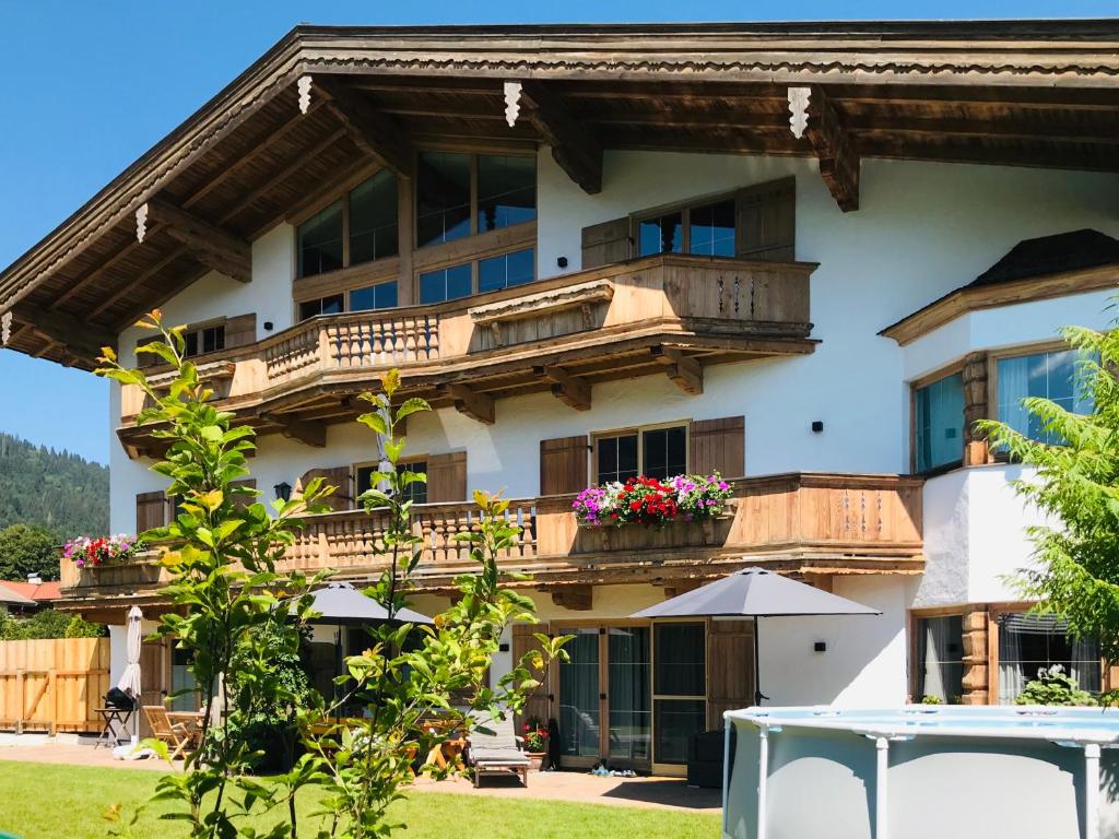 ein Gebäude mit einem Balkon mit Blumen darauf in der Unterkunft Apartment Hahnenkammblick in Reith bei Kitzbühel