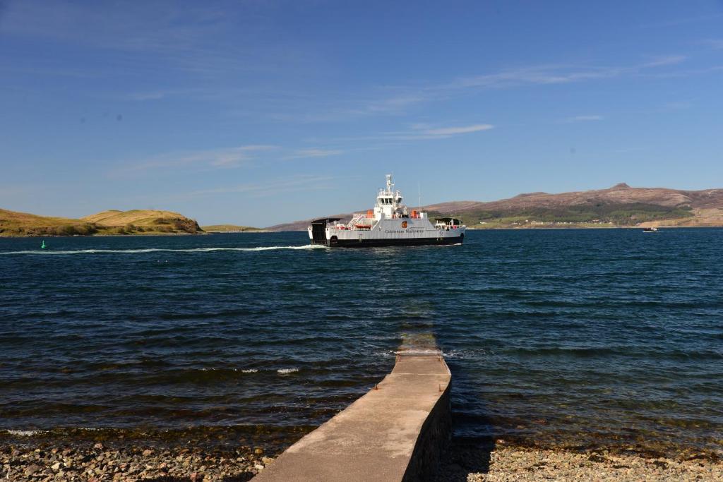 a boat in a large body of water with a dock at Sconser Lodge Hotel in Sconser