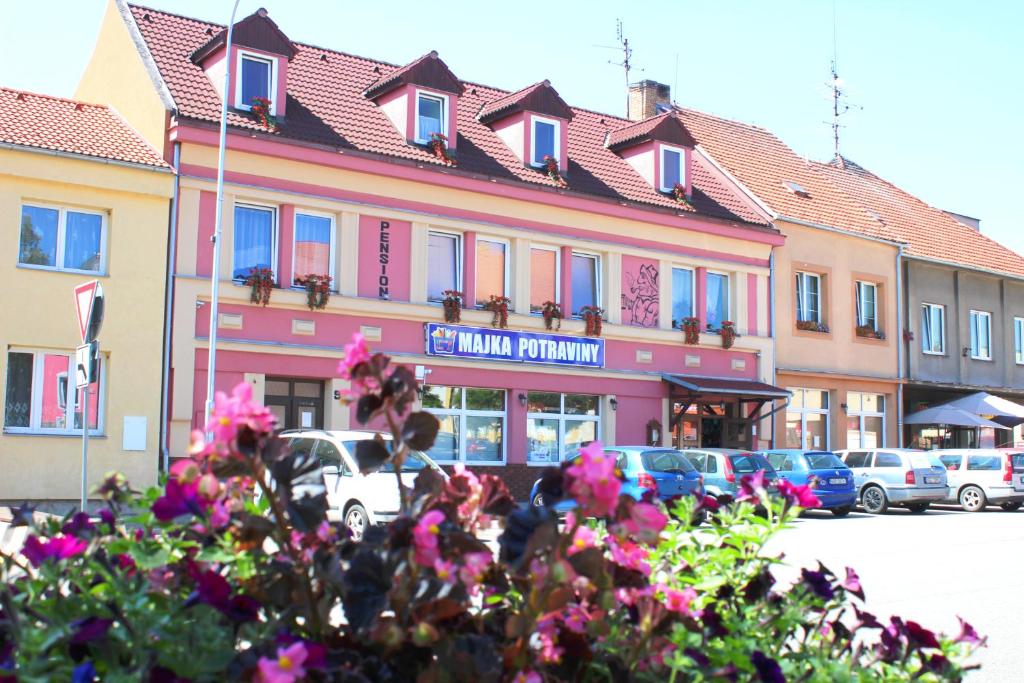 un edificio con flores rosas delante de él en Pension Bernartice, en Bernartice