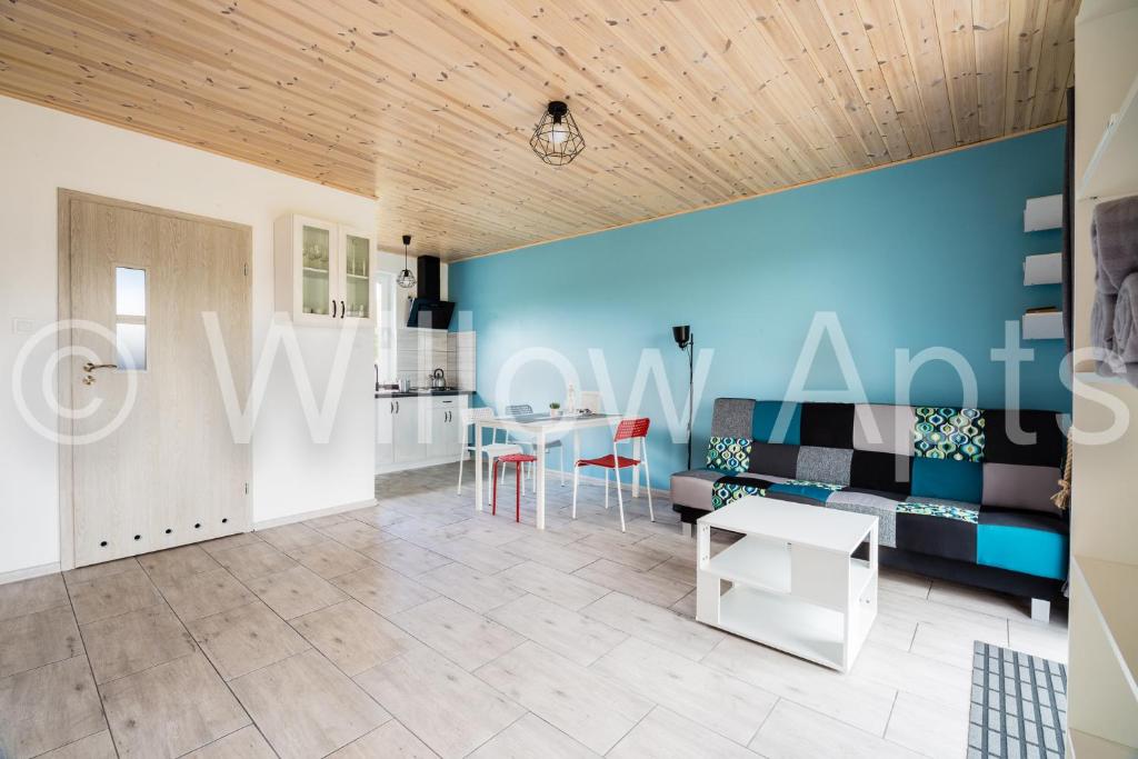 uma sala de estar com uma mesa e uma parede azul em Willow Apts em Junoszyno