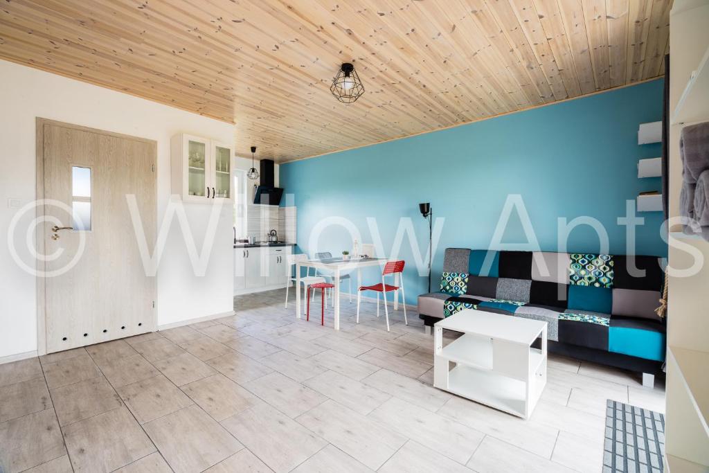 ein Wohnzimmer mit einem Tisch und einer blauen Wand in der Unterkunft Willow Apts in Junoszyno