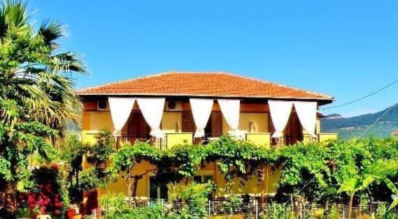 a large yellow building with a bunch of vines at Barbara Studios in Skala Potamias