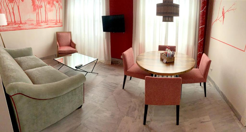 a living room with a couch and a table and chairs at Ritual Sevilla Suites Alameda 1 in Seville