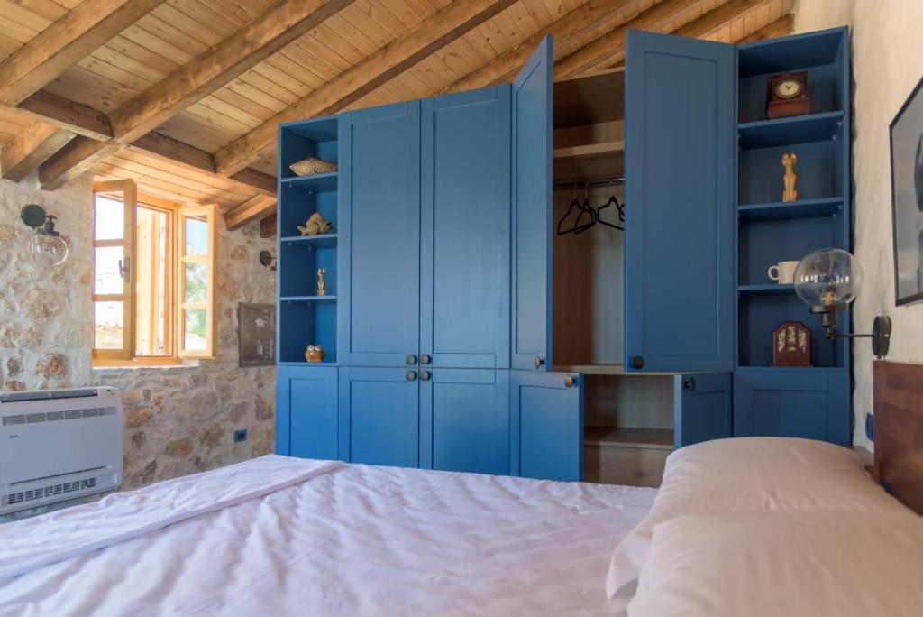 a bedroom with blue cabinets and a bed at Roots Dhermi in Dhërmi